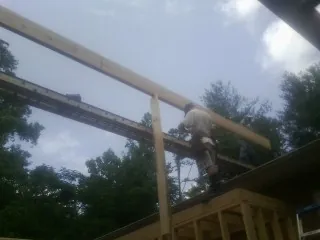 Carpenter setting a ridge beam over a new addition frame — Ice Dam Removal by Roofing Brothers in Boone