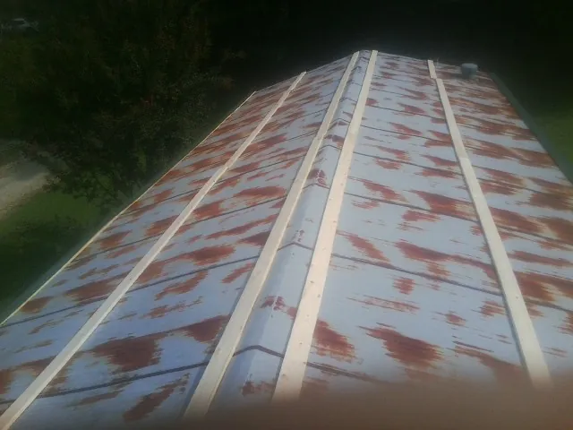 Rusted metal roof panels with new wood purlins before replacement — Storm Damage Roof Repair in Boone by Roofing Brothers