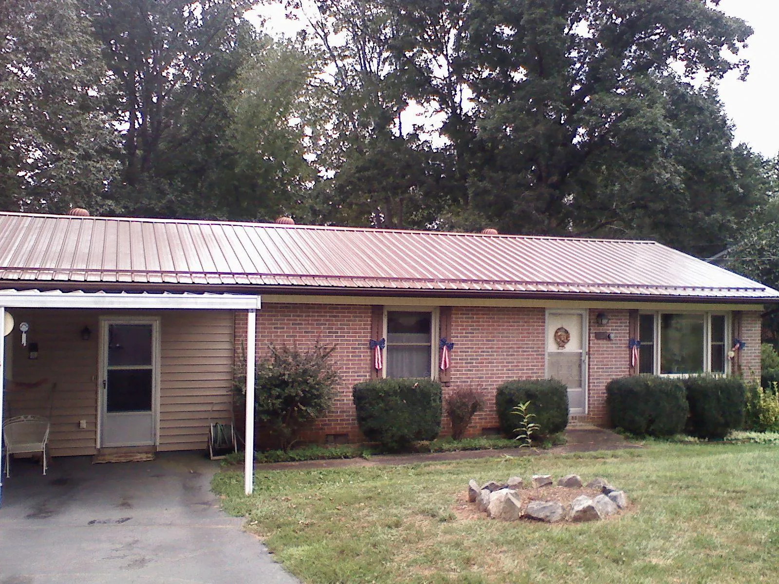 Bronze metal roof and carport on a brick ranch home — Roof Repair work by our crew in Boone